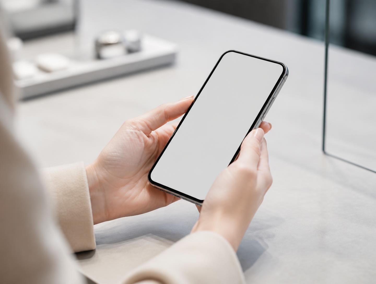 A person holding a phone at a clean counter